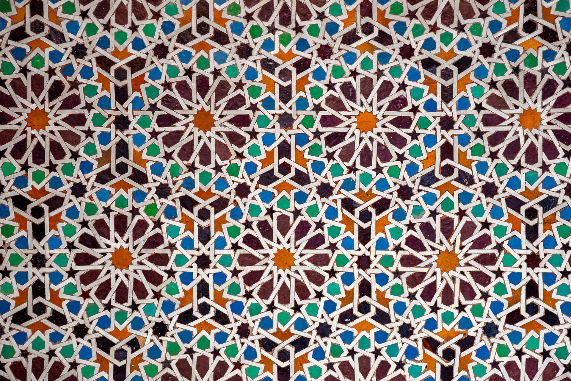 Colorful traditional Moroccan zellije mosaic pattern in Marrakesh, Morocco, showcasing intricate Islamic geometric art and centuries-old craftsmanship hand-cut tiles, reflecting cultural heritage.